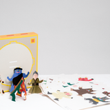 Kokuyo's Tonton Paper Sumo Game, designed in Japan by Cochae and available at NiMi Projects, with a storage box that doubles as a sumo ring, and several pages of paper characters, including a wild boar, sheep and horse. Four characters are made and standing by the box — an old lady, blue demon, goldfish and a green mythical creature. 