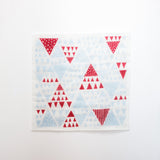 A Kaya Kiji dishcloth at NiMi Projects, made with traditional Japanese cotton mosquito netting and inner layers of natural fibre rayon, and printed with a  pattern of red and blue triangles. Made in Japan. 