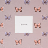A closeup of a notebook, made in Japan and available at NiMi Projects UK, featuring pink and purple butterflies on a grey background.
