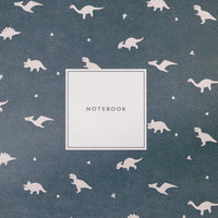 A closeup of a Japanese notebook available at NiMi Projects UK, featuring different dinosaur motifs on a dark green background.