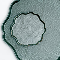 A detail of a Japanese porcelain Mino-yaki flat platter with a matching dish on top, in bottle green, with a criss-cross texture and raised Arabesque edges.