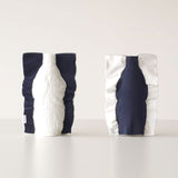 Two Moheim Silhouette vases, displayed side by side to show both sides of the product. The knitted vase features a silhouette of a bottle in white on a navy blue background on one side, and a navy blue silhouette on a white background on the other.
