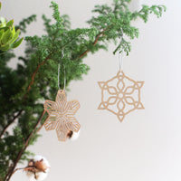Two Shina wood Christmas decorations, cut in the shape of snowflakes, made in Japan by Sukima and available at NiMi Projects UK.