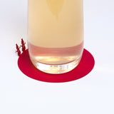 A red laser-cut paper coaster, designed by Terada-Mokei, featuring the silhouettes of a pair of snowmen on the edge, folded up to appear standing on the edge of the circle. Available at NiMi Projects UK. 