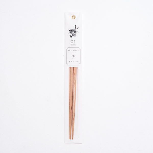A pair of chestnut wood Tetoca chopsticks in paper packaging featuring an illustration of chestnuts and leaves, made by Kawai in Japan and available at NiMi Projects UK