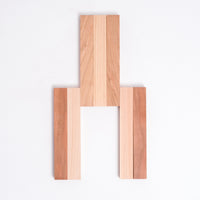 A slatted  Cherry wood and Hinoki Japanese Cypress trivet made of seven hinged slats, with the three central slats opened. Made in Japan by Tosa Ryu and available at NiMi Projects UK. 