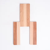 A slatted  Cherry wood and Hinoki Japanese Cypress trivet made of seven hinged slats, with the three central slats opened. Made in Japan by Tosa Ryu and available at NiMi Projects UK. 