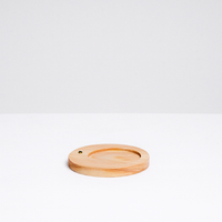 A circular wood incense stand, with an indent for a heatproof mat for paper incense and a side hole for traditional Japanese stick incense, designed by Trunk Design in Japan and available at NiMi Projects UK.