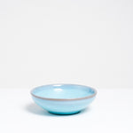 A side view of a small blue vintage Japanese ceramic round bowl.