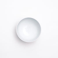 Top view of a white vintage Japanese porcelain teacup, featuring a blue line detail inside the rim.