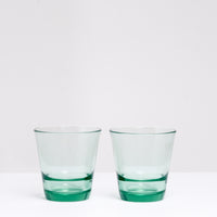 A pair of green Japanese glass Spash, stackable tumblers, made by Toyo Sasaki Glass and available at NiMi Projects UK.