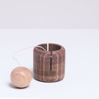 A brown wooden Ototama cup and ball game, handmade by Tsumikido in Japan and sold at NiMi Projects UK.